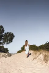 Vestido midi blanco con estampado floral en tonos verdes, escote en V, mangas cortas abullonadas y corte evasé con abertura lateral.