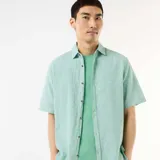Camisa de manga corta en mezcla de lino color verde menta, con cuello camisero, cierre frontal de botones y diseño holgado.