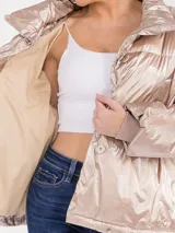 Campera puffer de corte oversize en tono champagne metalizado, con cuello alto envolvente y acabado brillante.