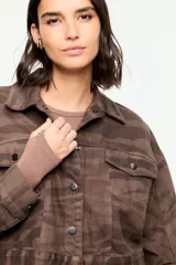 Chaqueta de denim de corte corto en tono marrón con estampado de cebra, cuello camisero, cierre frontal con botones metálicos y bolsillos delanteros con solapa.