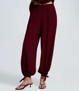 Pantalón estilo aladino color bordó, confeccionado en tejido crepé con textura. Presenta cintura elástica, corte holgado en las piernas y ruedo ajustado con lazo decorativo.
