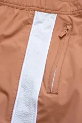 Short de baño color ladrillo con cintura elástica y cordón ajustable. Presenta una franja lateral blanca estilo esmoquin, dos bolsillos laterales y uno trasero con cierre.