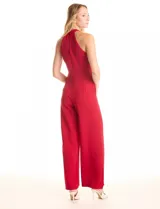 Enterito largo de crepe color rojo, con escote halter anudado y pierna ancha. Presenta bolsillos delanteros y abertura en la espalda con cierre invisible y botón.