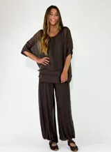 Pantalon de viscosa color marrón, de corte amplio y fluido con botamanga fruncida y cintura elástica ancha.