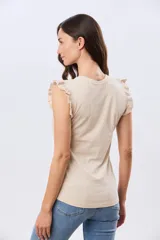 Remera lisa de algodón color beige, sin mangas, con detalles de volados en los hombros y cuello redondo.