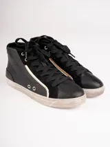 Botitas negras de caña alta con cordones y suela blanca.