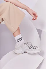 Pantalón recto color beige con cintura elástica y cierre metálico.