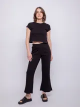 Pantalón negro de tejido de punto acanalado, de corte ancho y tiro alto con elástico en la cintura.