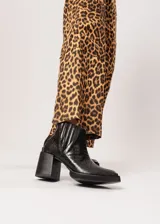 Botín negro de cuero con elástico lateral y cierre interno. Tiene plataforma delantera de 2 cm y taco de 8 cm.