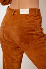 Pantalón de cuero ovino italiano color crema, de corte recto con tajos laterales en el ruedo.
