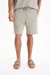 Bermuda deportiva sin friza color gris claro, de corte semi baggy y suelto. Cuenta con cintura elastizada, cordón ajustable y terminación lavada.
