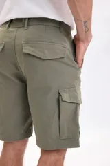 Bermuda cargo color verde militar, con bolsillos laterales con solapa y cierre de botones.