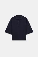 Camiseta polo de manga corta, color azul marino, con cuello solapa y cierre frontal de cuatro botones.