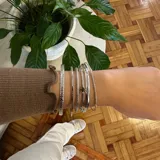 Set de seis pulseras plateadas tipo esclava. Tres de ellas son ajustables y las otras tres tienen un diámetro de 7 cm.