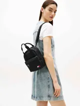 Mochila negra de poliéster reciclado de la marca Tommy Jeans, con doble asa superior y correas ajustables que permiten usarla también como bolso. Cuenta con un compartimento principal con cierre, un bolsillo frontal con cierre y el parche con el logo bordado en la parte inferior.