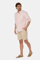 Bermuda clásica de lino color beige, de corte recto con bolsillos laterales y traseros ribeteados con botón.