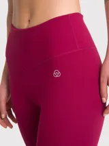 Calza deportiva de tiro alto con largo hasta el tobillo, confeccionada en tejido elástico de color bordó.