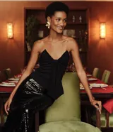 Blusa negra de bengalina, sin tirantes, con escote triangular y un lazo aplicado en el centro.