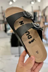 Sandalia marrón con diseño de dos tiras ajustables con hebillas metálicas y plantilla anatómica.