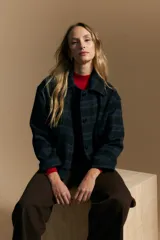 Tapado corto de lana con diseño a cuadros en tonos azul y negro, cuello camisero y cierre frontal con botones.