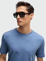 Remera de algodón de corte regular, color gris oscuro, con cuello redondo y logo de la marca bordado discretamente en el pecho.