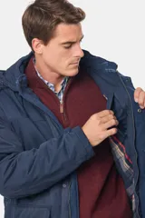 Campera azul con capucha desmontable, cierre frontal con cremallera y botones a presión, múltiples bolsillos y forro interior a cuadros.