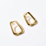Aros colgantes dorados con forma geométrica irregular.