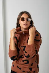 Buzo de tejido de punto con estampado animal print, cuello alto con cierre frontal y mangas largas.