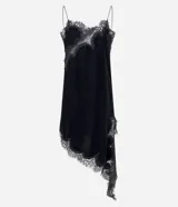 Vestido corto de terciopelo negro, estilo slip dress, con escote corazón, breteles finos y detalles de encaje en el escote y en el ruedo asimétrico con terminación en punta lateral.