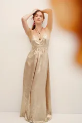 Vestido largo dorado de poliéster metalizado con tirantes finos, escote en V y corte fluido.
