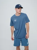 Remera deportiva Umbro modelo Vant, de color negro con paneles laterales grises y cuello redondo, diseñada para hombre.