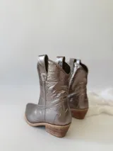 Botas texanas de cuero color peltre con bordados en el empeine y caña media.