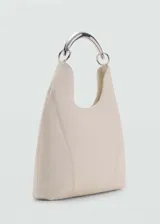 Bolso de hombro color crema, de tamaño mediano, con asa corta metálica plateada y cierre de botón magnético. Confeccionado en piel bovina con forro interior de algodón.