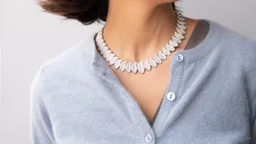 Collar corto plateado con diseño de hojitas brillantes.