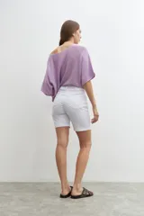 Bermuda de denim blanca, tiro medio, con cinco bolsillos y dobladillo en el borde de la pierna.