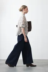 Camisa de manga larga con cuello con volados y botones nacarados. Presenta un estampado romántico de inspiración barroca en tonos azul y beige.