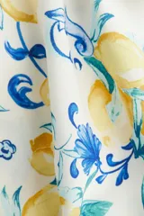 Vestido túnica a la rodilla en tejido liviano de viscosa con cuello mao y abertura en V. Modelo de corte holgado con hombros levemente caídos, mangas cortas y bajo recto con tajos laterales. Parte posterior algo más larga. Estampado de limones y flores azules.