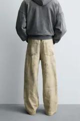 Pantalón de corte baggy fit confeccionado en tejido de algodón con textura y efecto lavado. Presenta diseño de cinco bolsillos, cierre frontal con cremallera y botón.