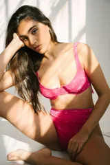 Conjunto de bikini fucsia aterciopelado, compuesto por un corpiño con aro y breteles regulables, y una bombacha colaless de tiro alto.