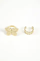 Set de dos anillos dorados. Uno con forma de mariposa y otro con diseño geométrico abierto.
