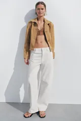 Jeans de tiro medio y corte barrel leg, color blanco roto. Presenta cinco bolsillos y cierre frontal con cremallera, botón y gancho metálico.