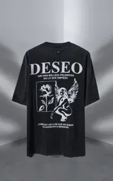 Remera de algodón premium con efecto nevado, corte oversize y cuello redondo. Presenta una estampa gráfica en color blanco en la espalda que incluye la palabra 'DESEO', una ilustración de una rosa y una figura alada, junto con frases poéticas.