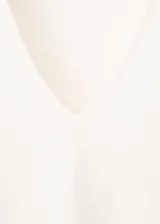 Camiseta de lino color blanco, con cuello en V y mangas cortas, de corte recto y clásico.