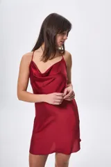 Vestido corto de satén color borgoña, con cuello drapeado y espalda cruzada con tirantes finos.