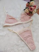 Conjunto de lencería compuesto por un corpiño triangular y una bombacha tipo tanga, confeccionados en algodón color salmón con detalles de puntilla en tono champagne.