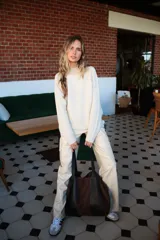 Bolso tipo shopper de gran tamaño, confeccionado en una combinación de cuero liso negro y gamuza marrón. Cuenta con correas de hombro integradas y un diseño espacioso con bolsillo interior.