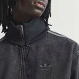 Campera Adidas Originals modelo Adicolor Denim Firebird, confeccionada en algodón denim de efecto desgastado. Presenta cuello alto, cierre frontal completo, bolsillos laterales y las clásicas franjas de la marca a lo largo de las mangas. Incluye el logotipo del Trifolio bordado en el pecho.