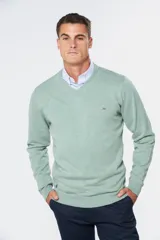 Buzo de tejido fino de algodón, color verde menta, con cuello en V y manga larga. Presenta un pequeño logo bordado en el pecho.