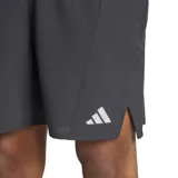 Short de entrenamiento Adidas HIIT HEAT.RDY, color gris oscuro (carbón), de corte ajustado y flexible, con cintura elástica y cordón. Presenta tejido texturizado, paneles de malla, bolsillos delanteros con cremallera y detalles reflectantes, incluyendo el logo de las tres barras en la parte inferior.