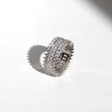 Anillo plateado con tres hileras de cristales de diferentes tamaños.